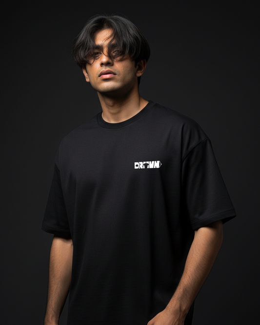 Person wearing a black t-shirt with drivnwear logo on a dark background