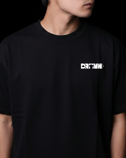 Person wearing a black t-shirt with a white logo on a dark background