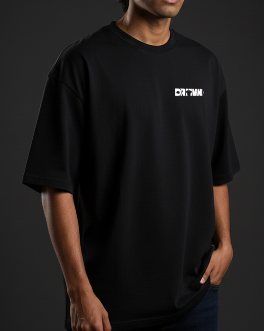 Person wearing a black t-shirt with drivnwear logo on a dark background