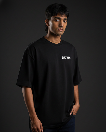 Person wearing a black t-shirt with a drivnwear logo on a dark background