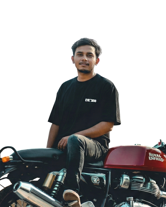 A man sitting on a gt650 wearing a drivnwear logo oversized tshirt