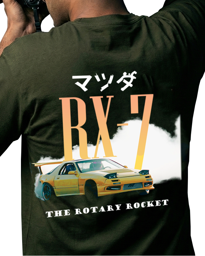 Person wearing a green t-shirt with Mazda RX-7 design, holding a camera.