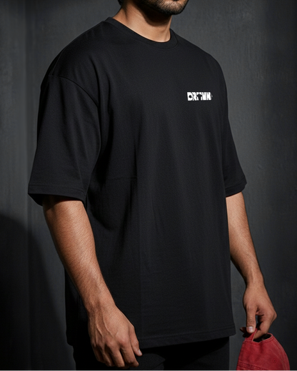 Man wearing a black t-shirt with a logo on a dark background